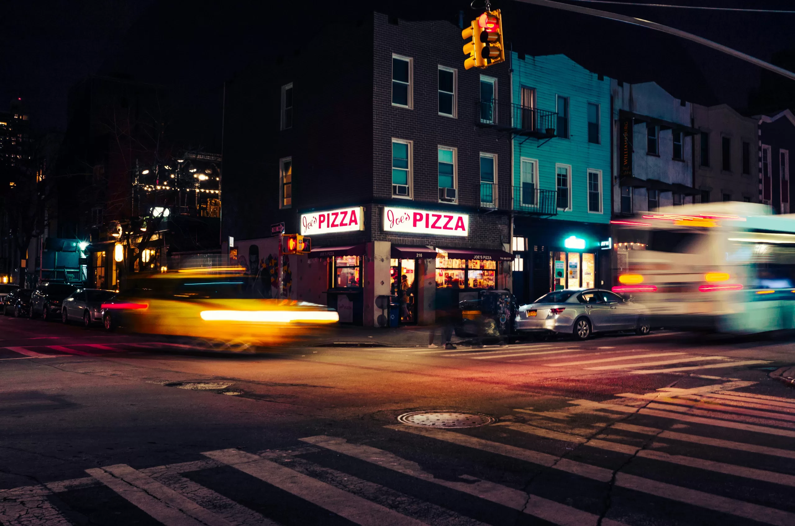 New York City street at night with motion-blurred lights, capturing the city-that-never-sleeps energy of a 3-day NYC foodie tour