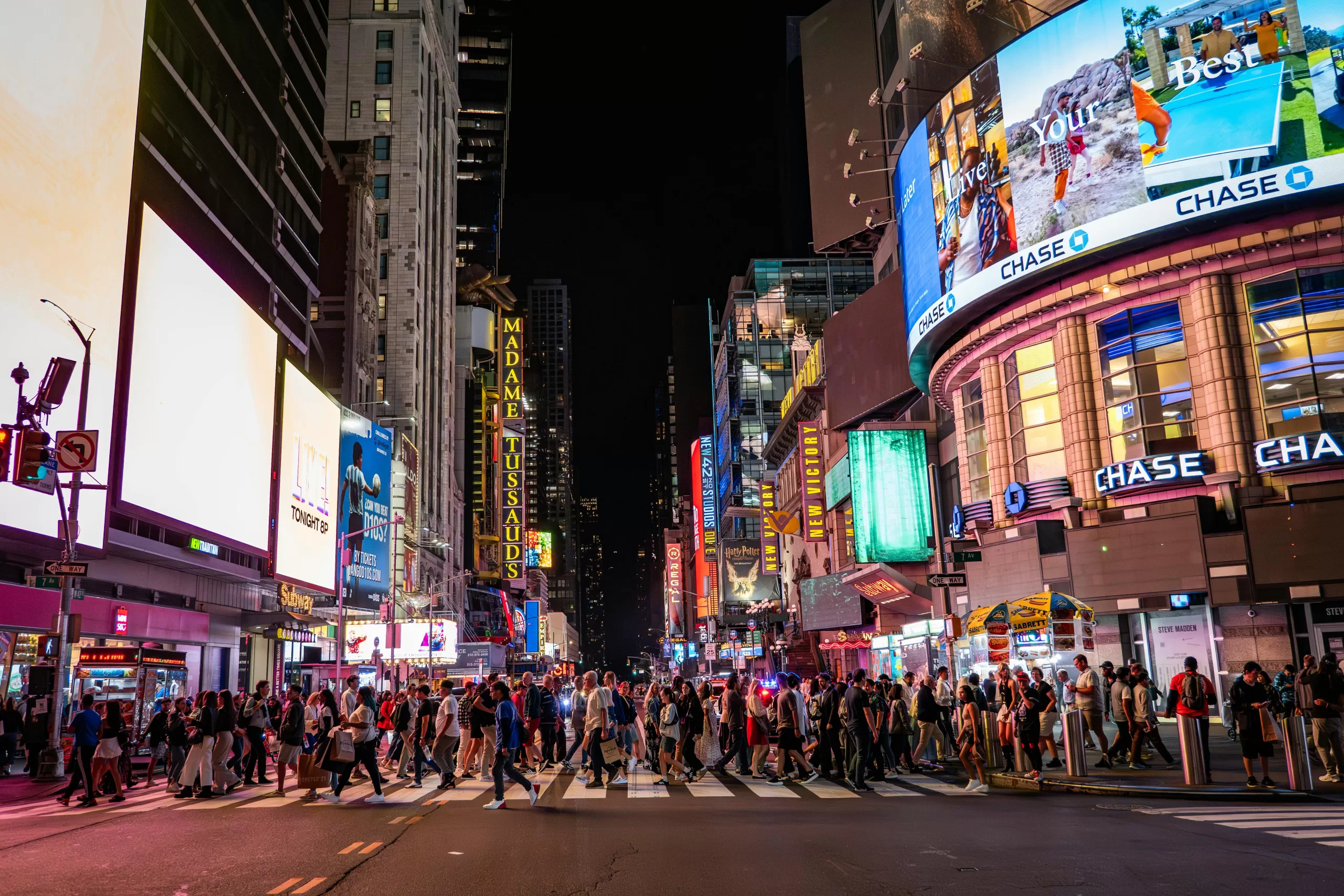 Times Square at night with bustling crowds and iconic billboards, a Midtown highlight on a New York City foodie tour Day 2