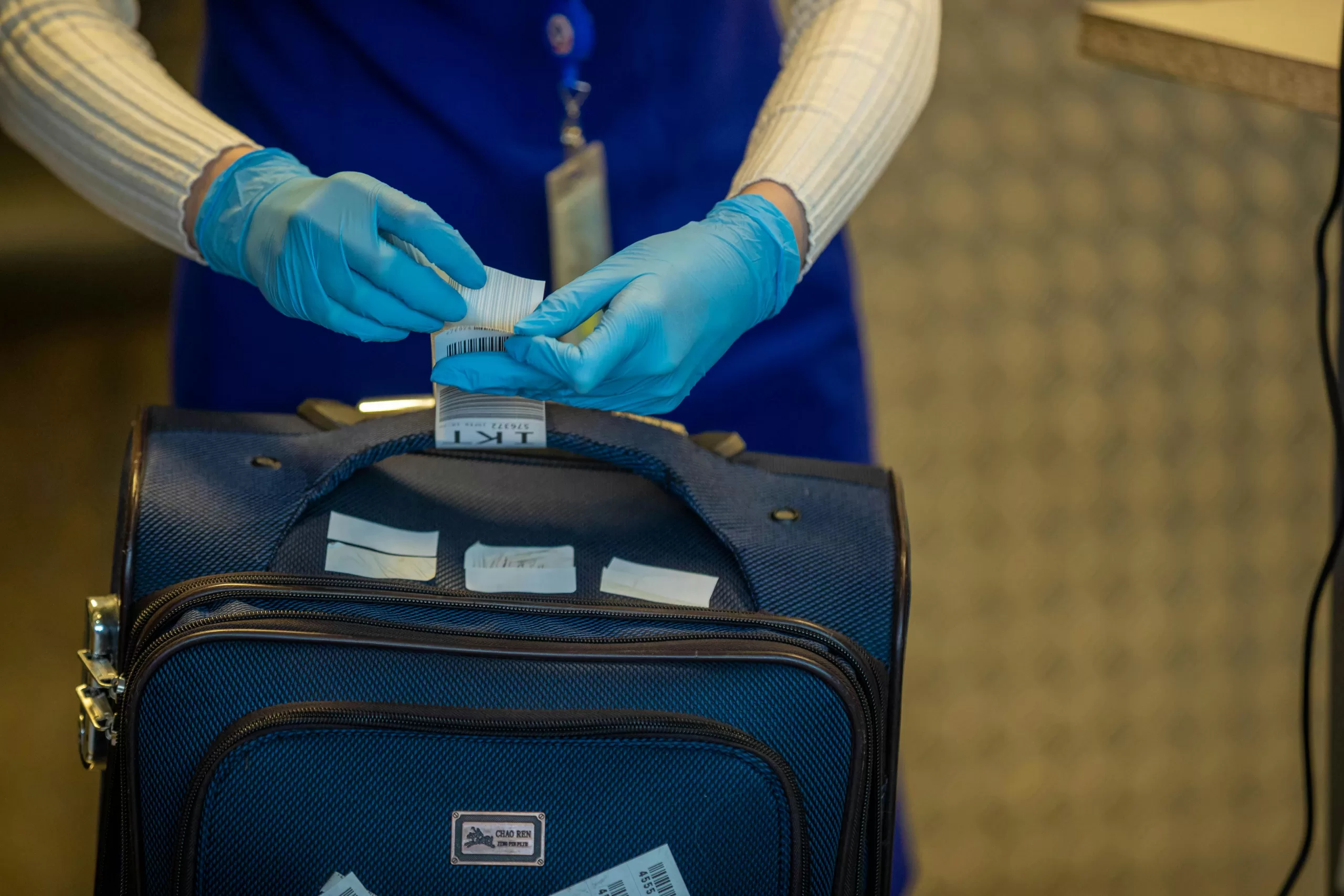 Airport security checkpoint with TSA inspecting luggage, the context for choosing a TSA-approved luggage lock